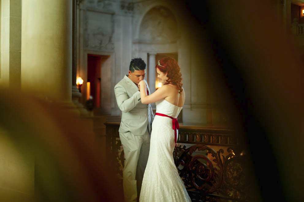 Groom kissing bride's hand at San Francisco City Hall wedding.